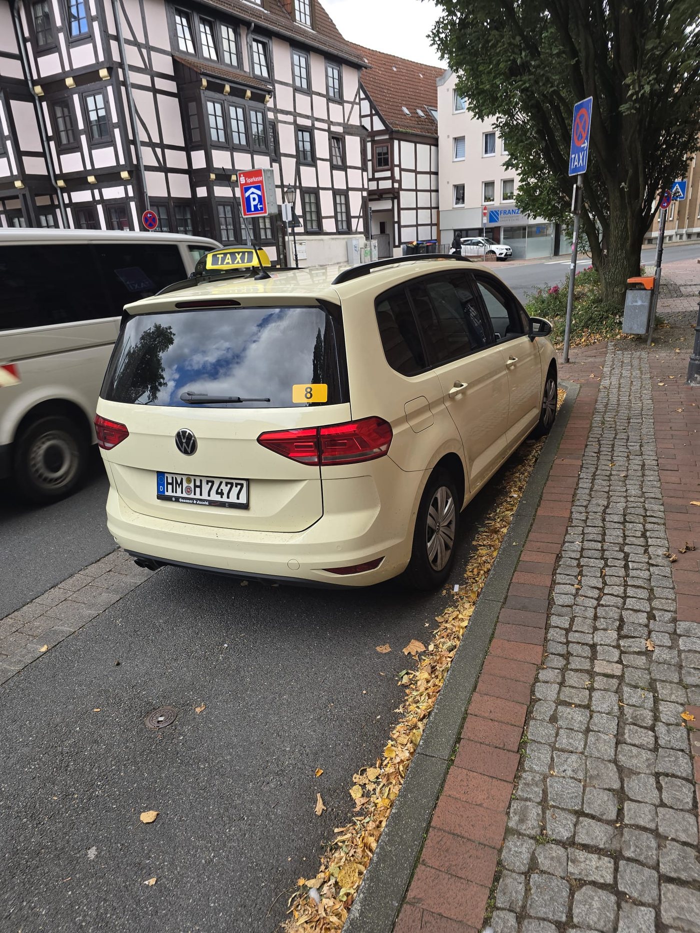 Taxi mit geöffneter hinterer Tür an einem Wohnstraßenrand